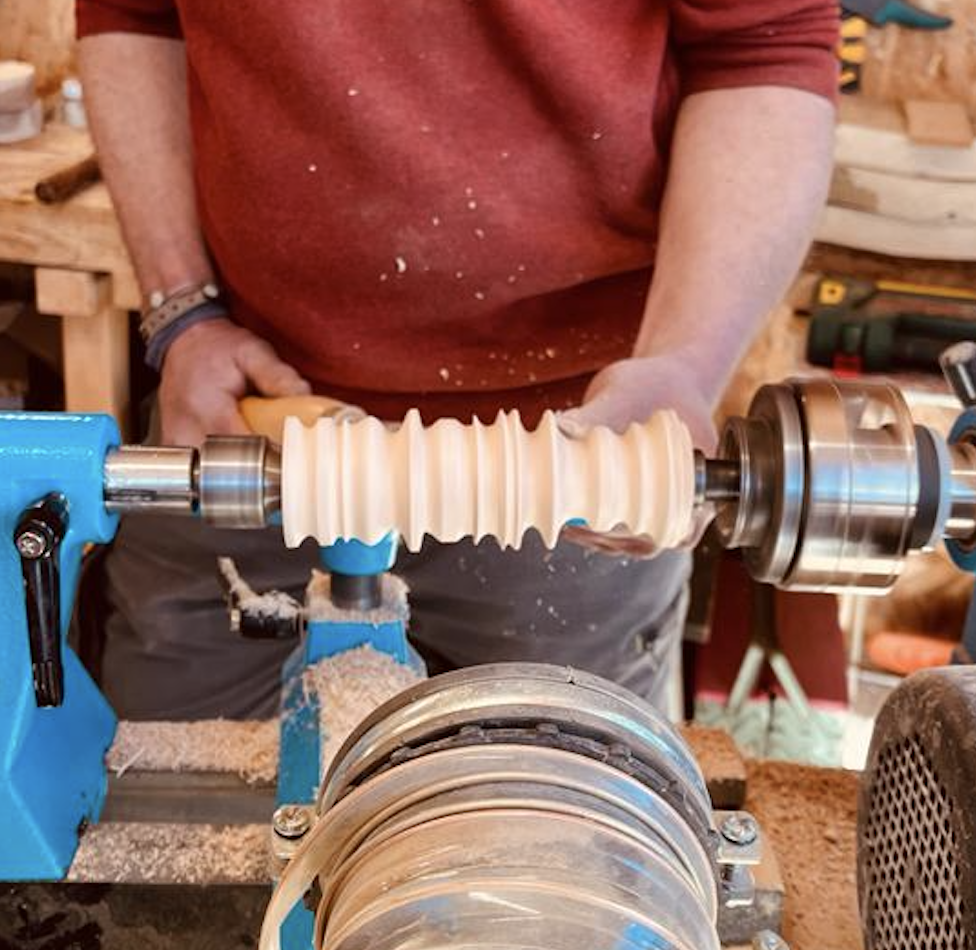 Un homme est en train de créer un objet en bois lors d'un atelier de WoodyWoodPeg. 