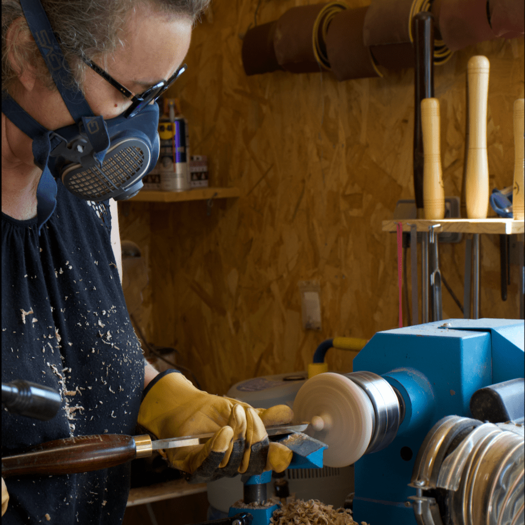 WoodyWoodPeg en train de tourner un couvercle d'une boîte